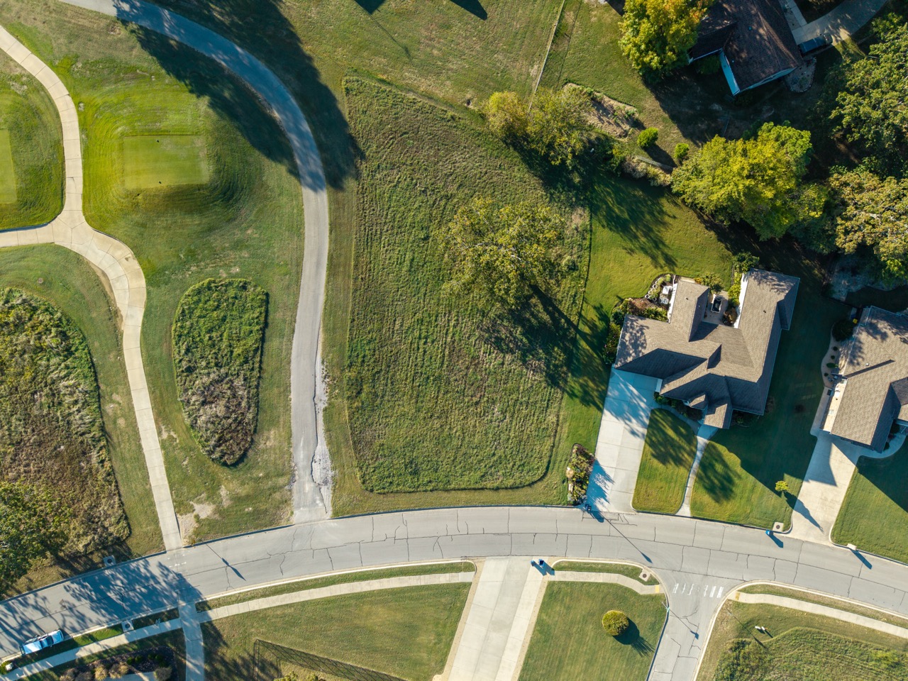 Aerial view of curved road intersection in a suburban neighborhood.