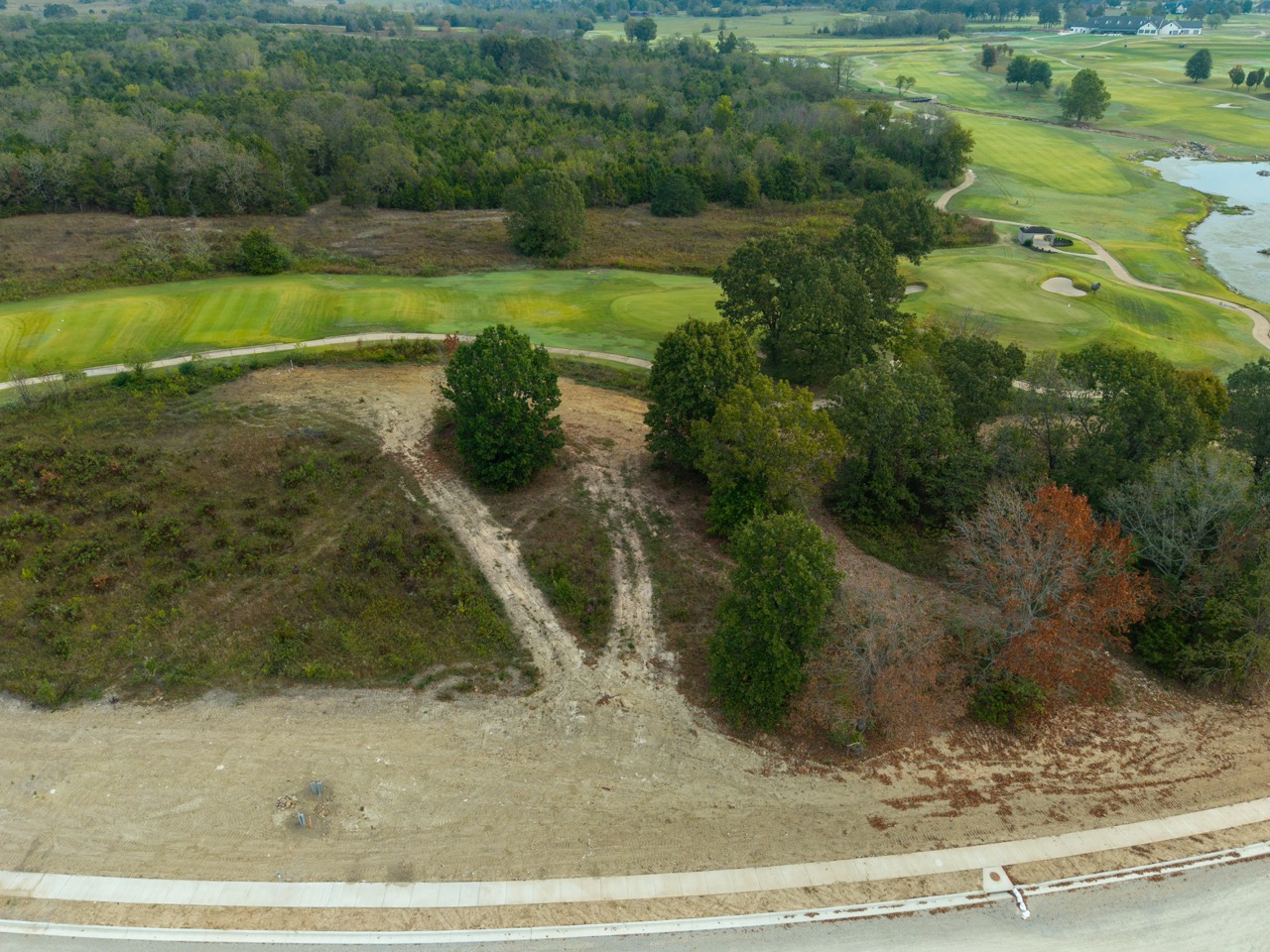 Cleared dirt lot with winding path and surrounding trees