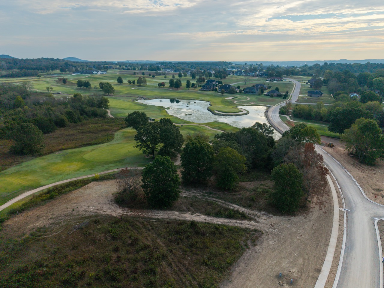Aerial view of golf course with ponds and winding cart path.