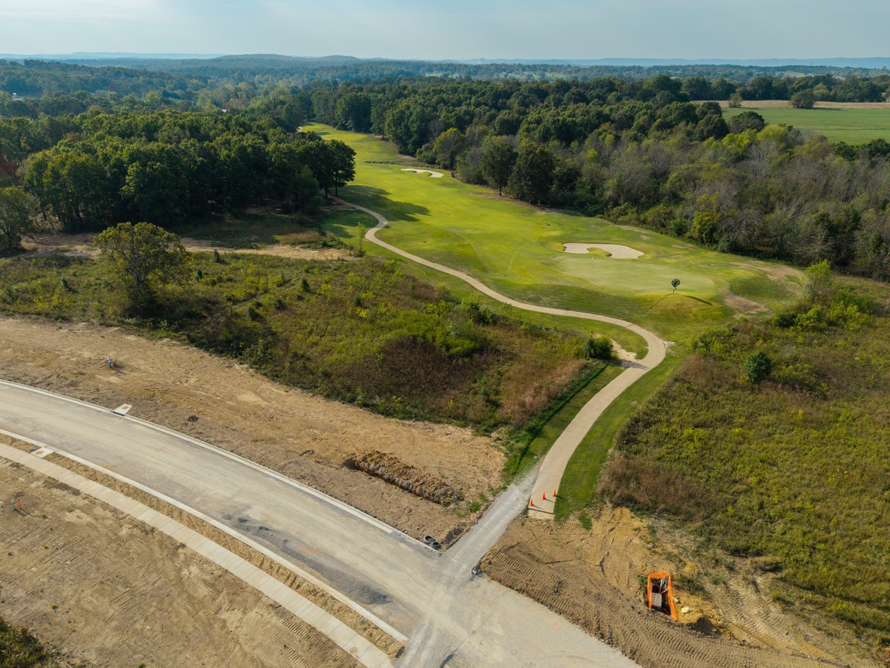Aerial view of winding golf course hole with fairway and green