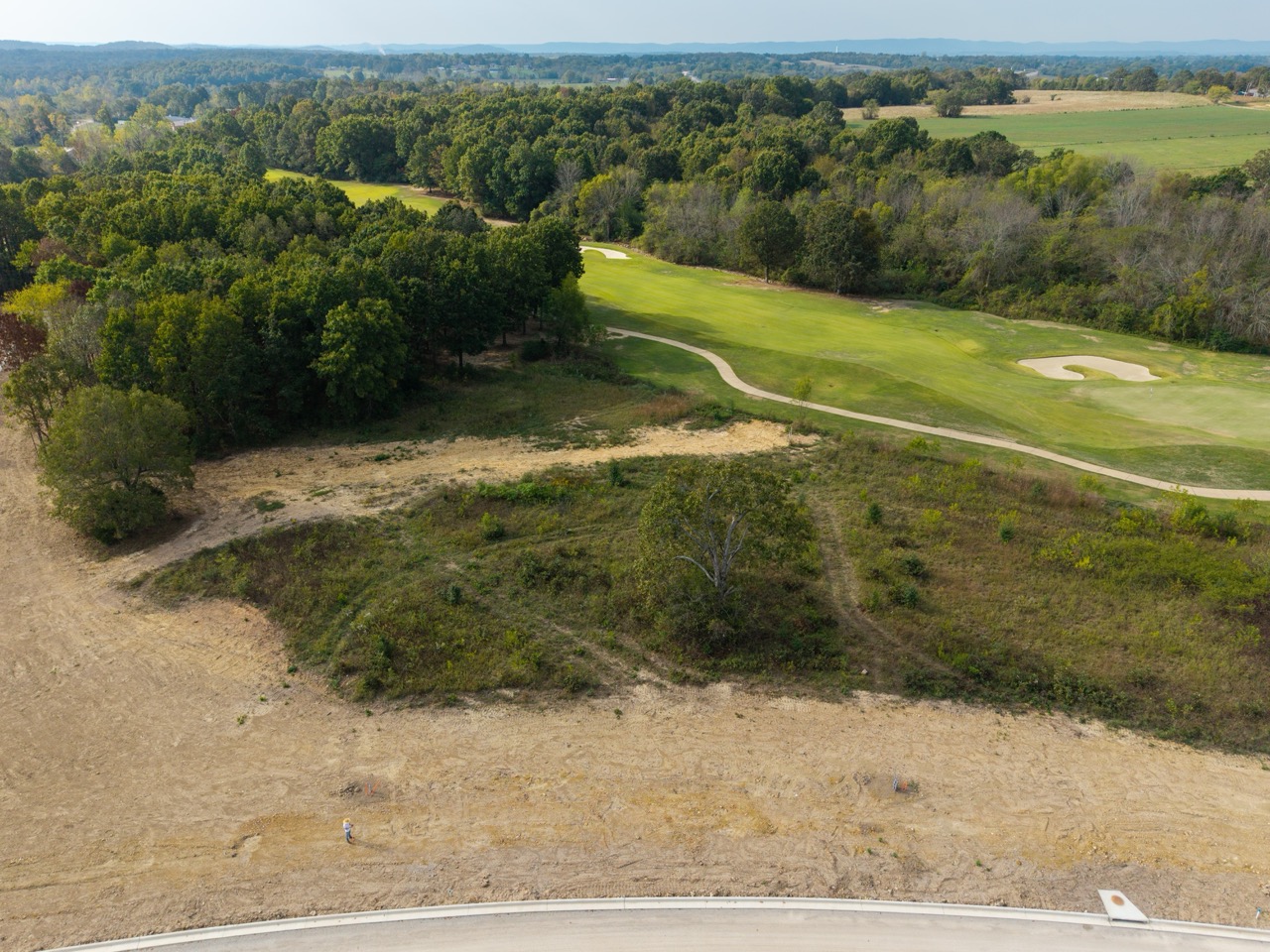 Golf course hole with sand bunker, green, and winding path
