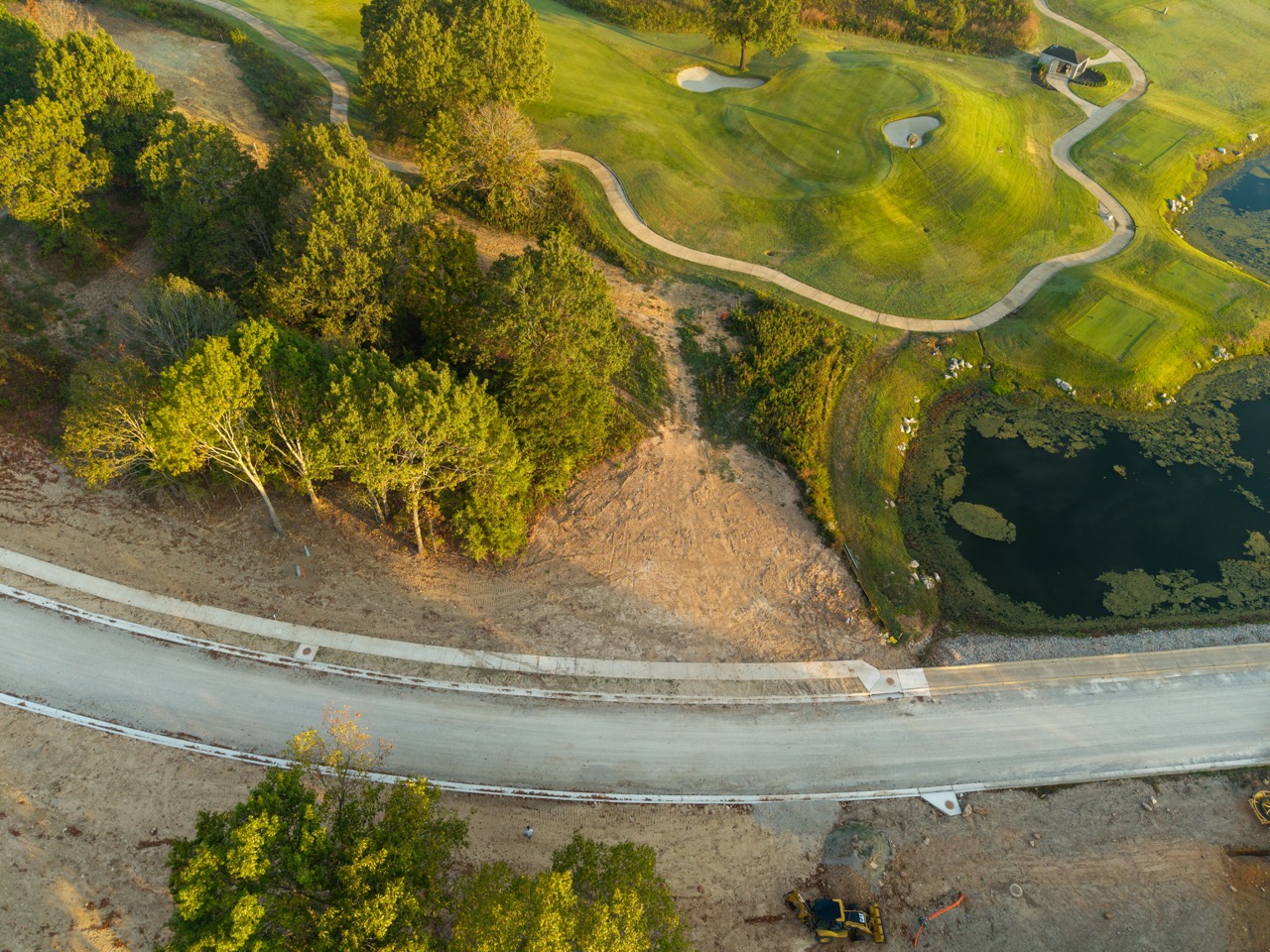 Aerial golf course with winding cart path and pond