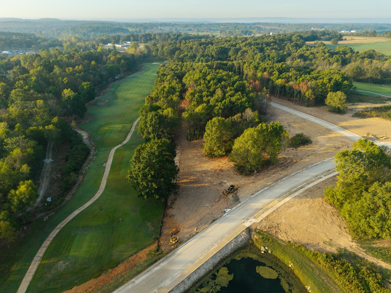 Aerial view of winding golf course fairway surrounded by trees