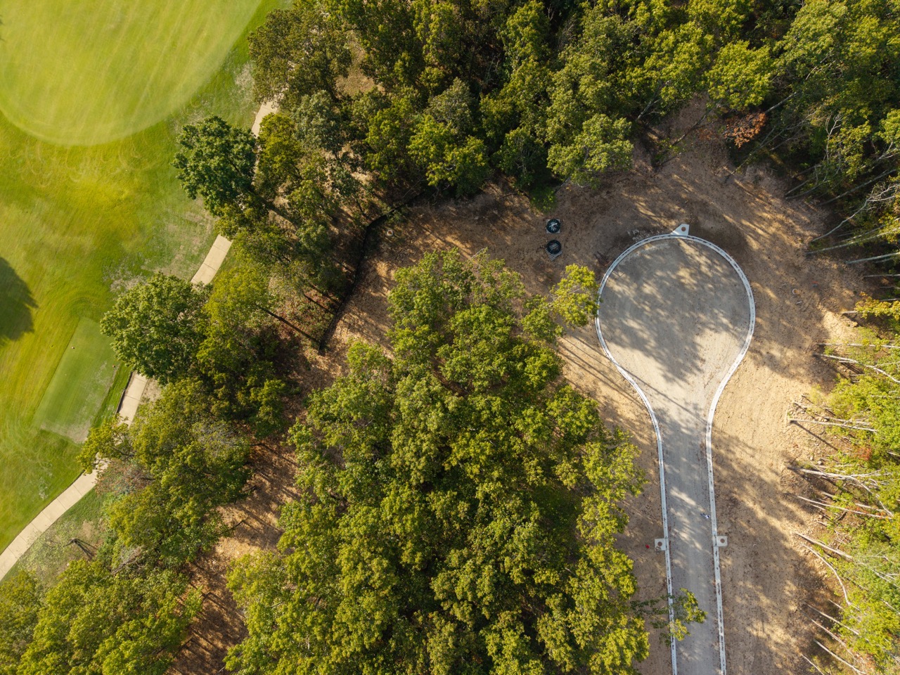 Circular concrete pathway looping through forested park.