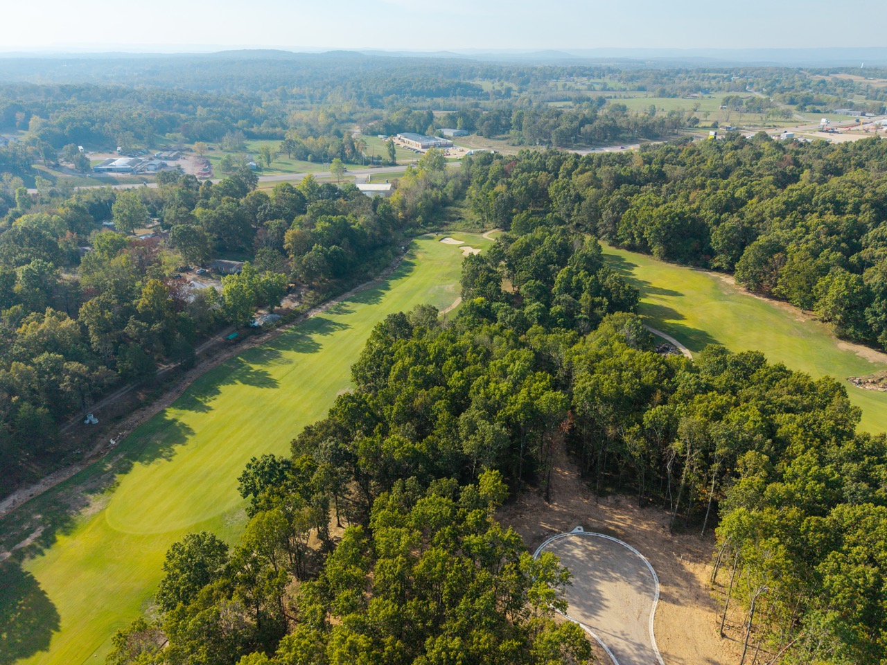 Aerial golf course fairway surrounded by trees