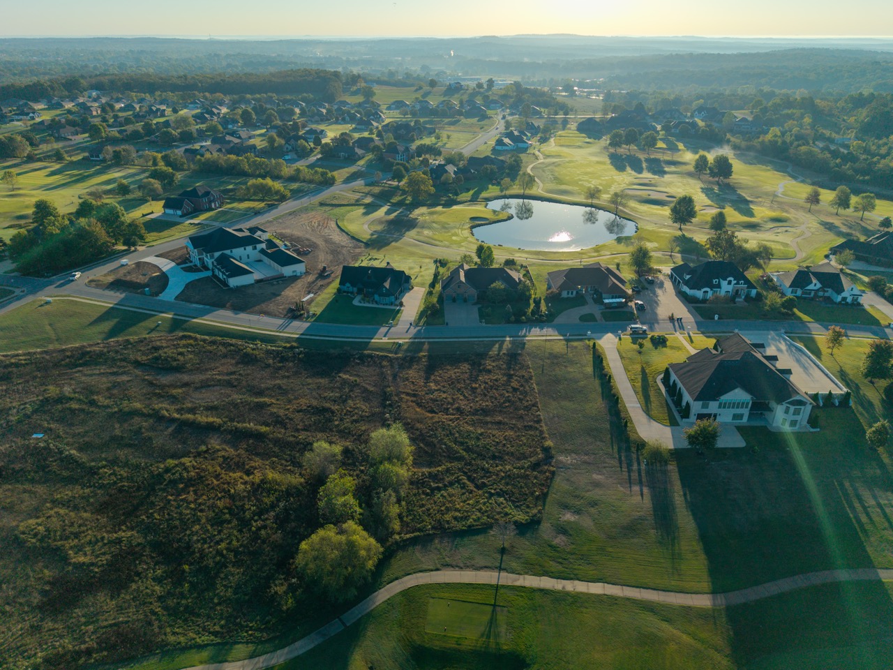 Suburban neighborhood surrounding central golf course pond