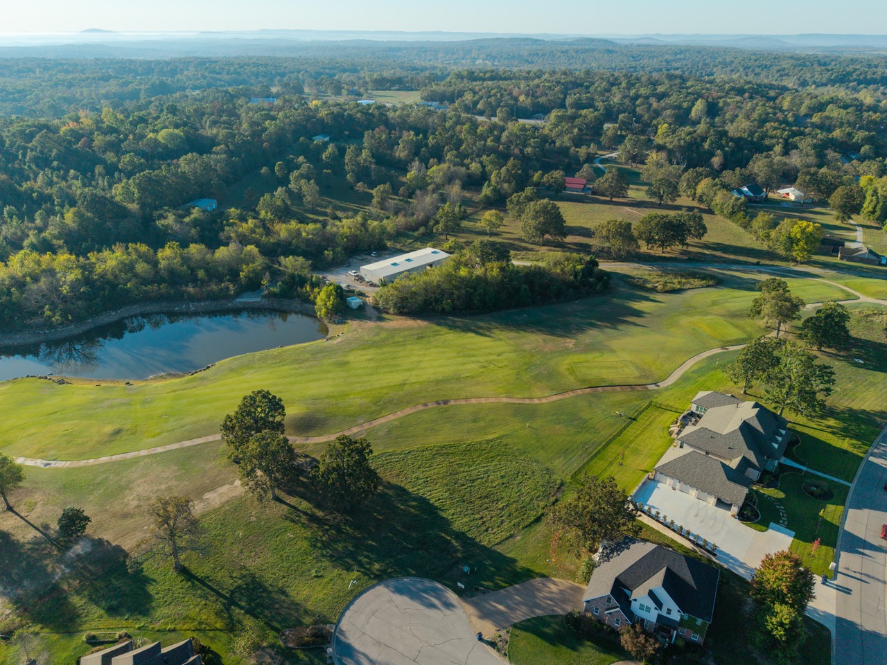 Aerial view of golf course surrounded by houses.