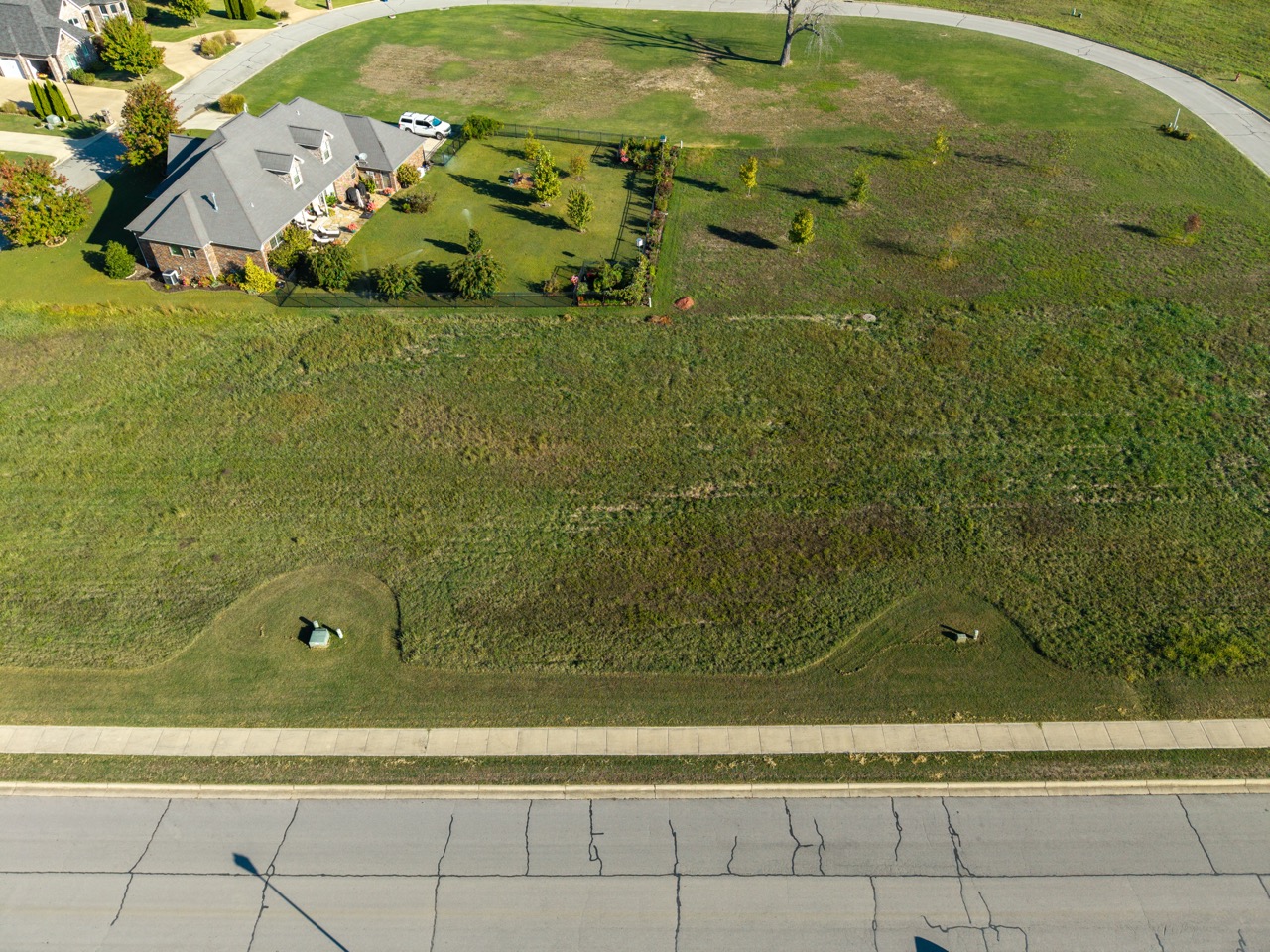Two-story brick house with gray roof and manicured lawn