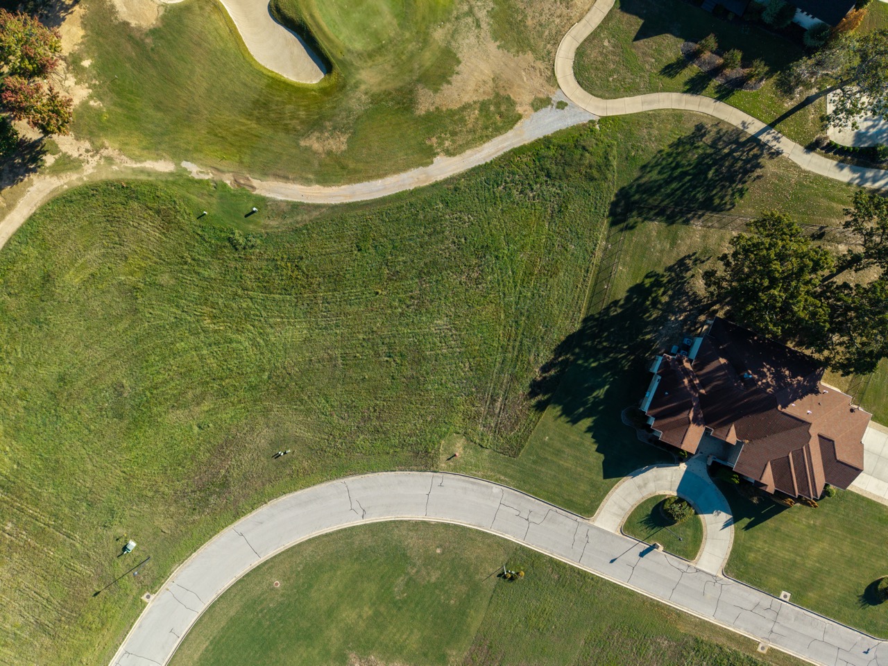 House with brown roof and circular driveway
