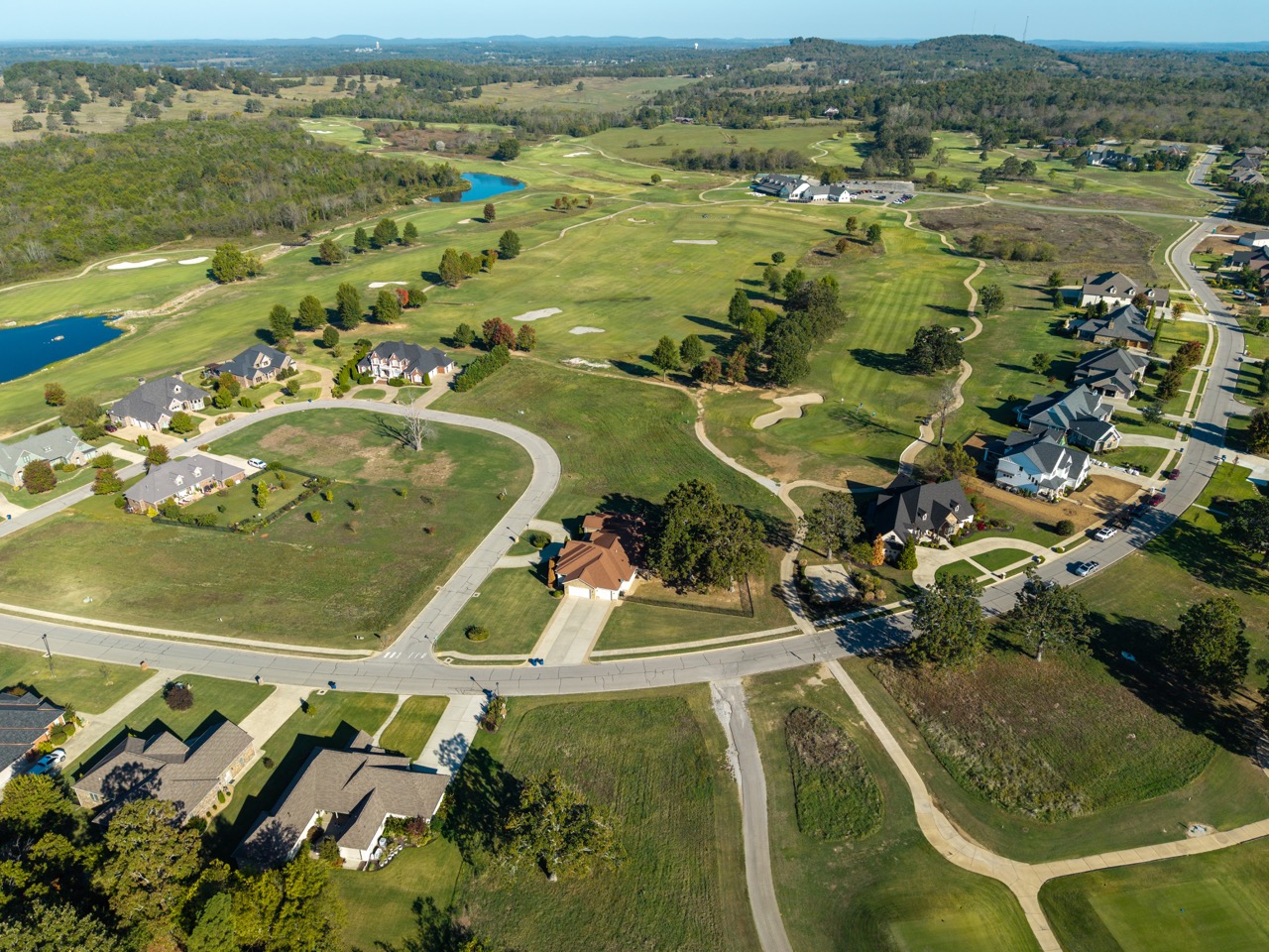 Golf course bordered by suburban houses and winding roads