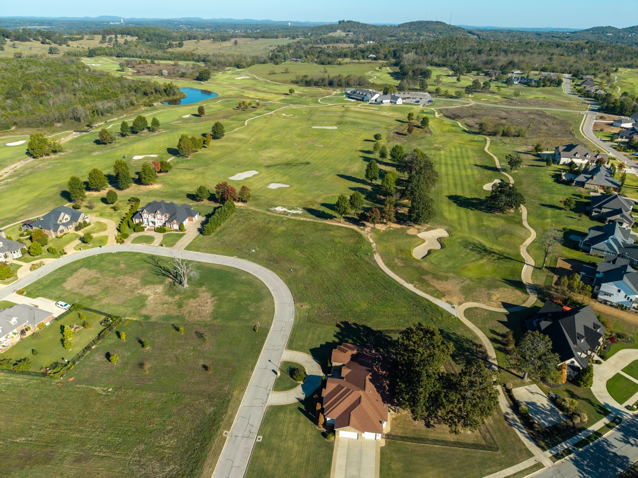 Aerial view of golf course with surrounding houses.
