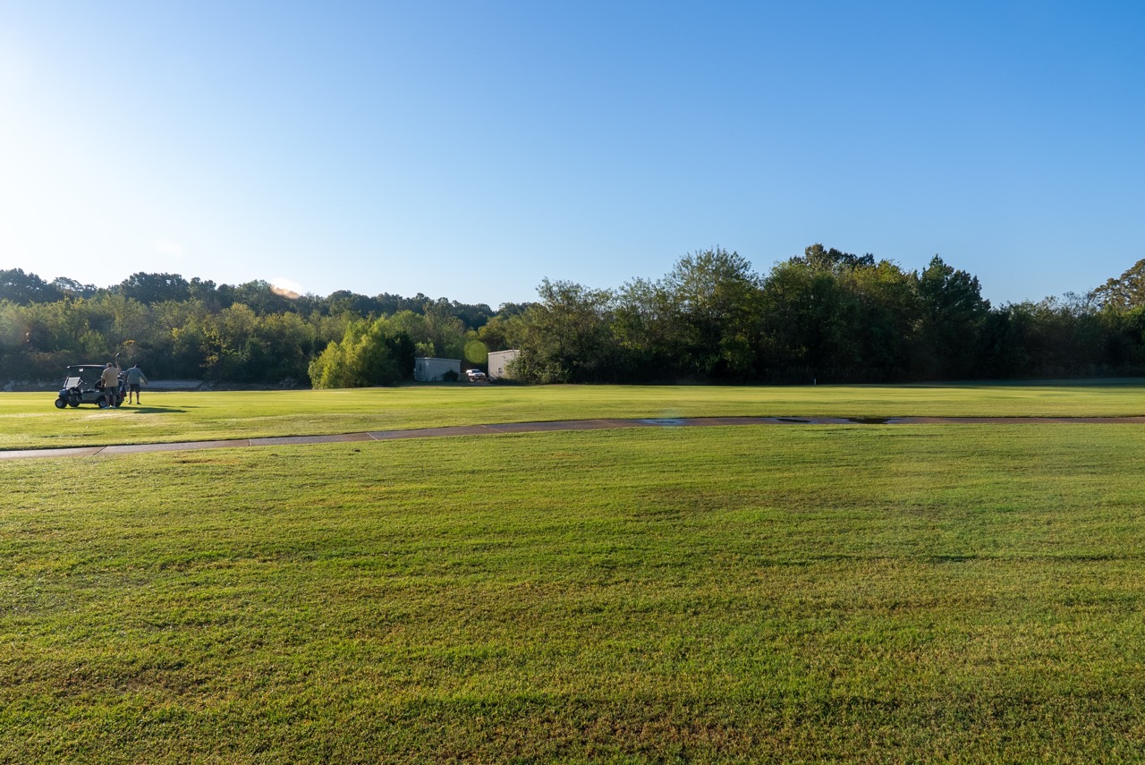 Golf cart and golfers on a golf course.