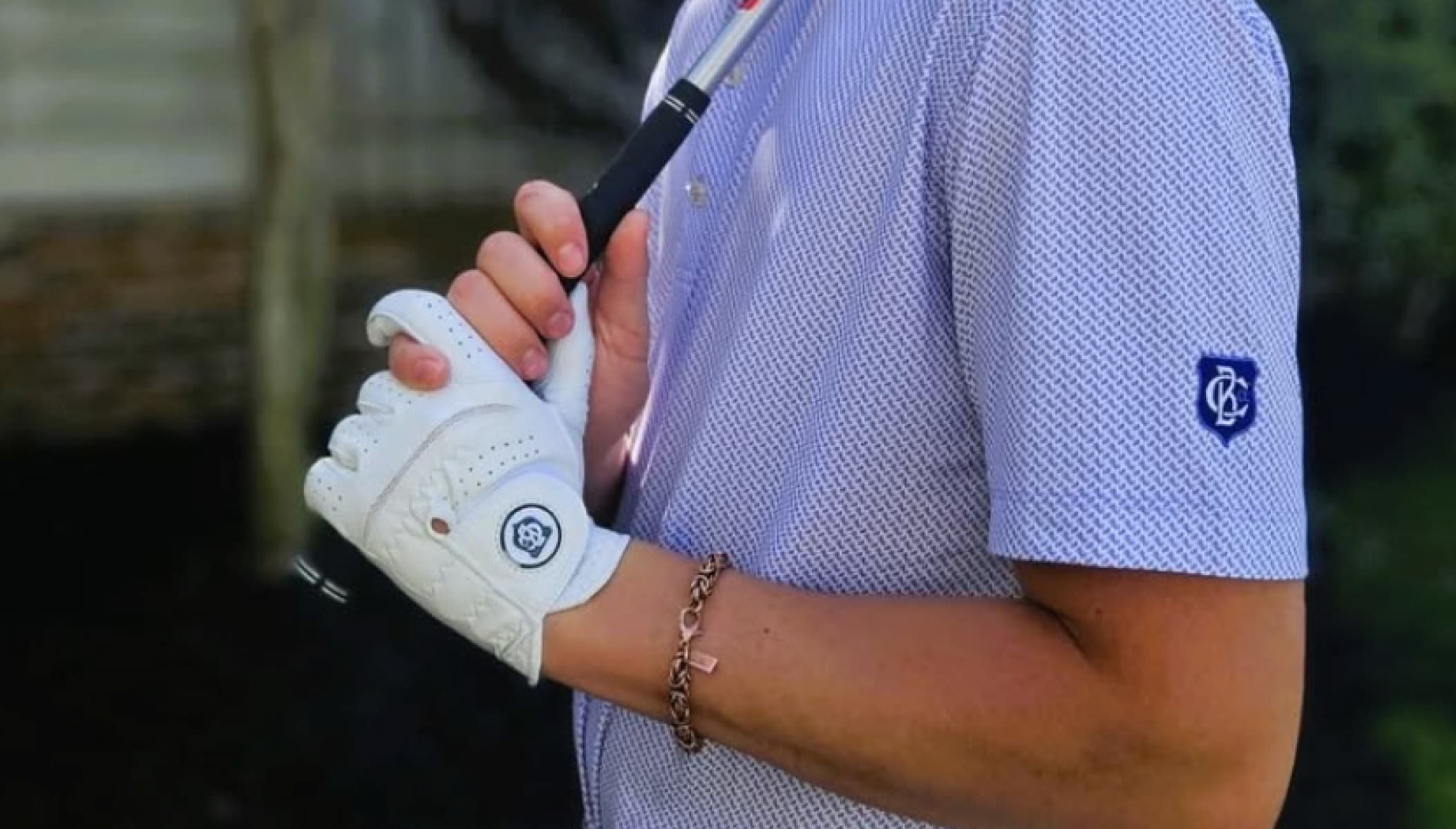 Golfer's white glove gripping golf club