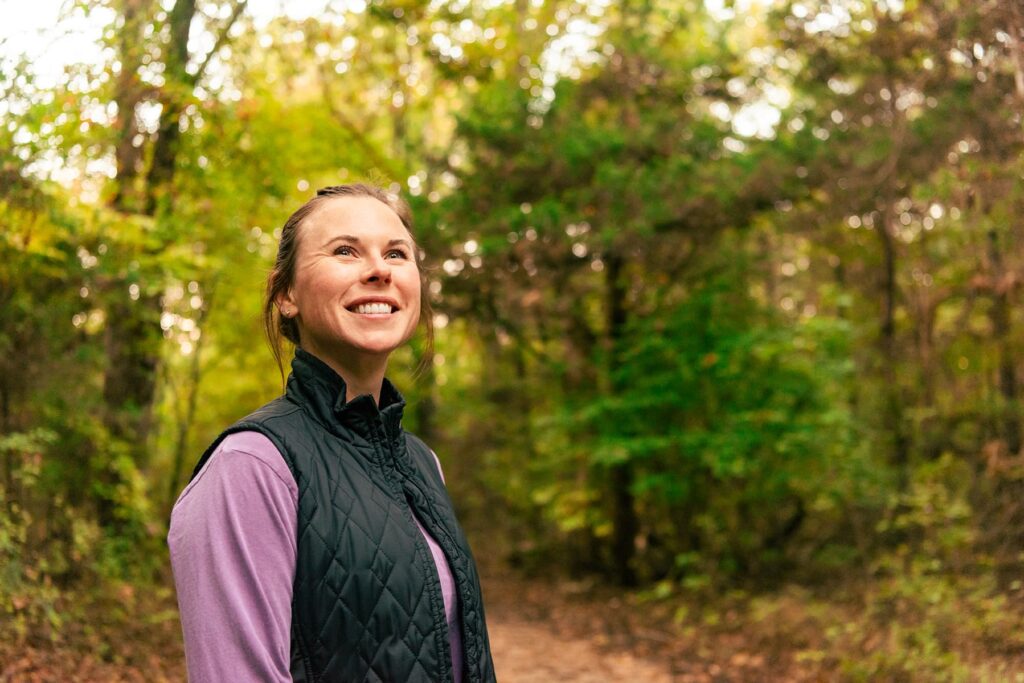 Woman wearing purple long-sleeve shirt and black quilted vest