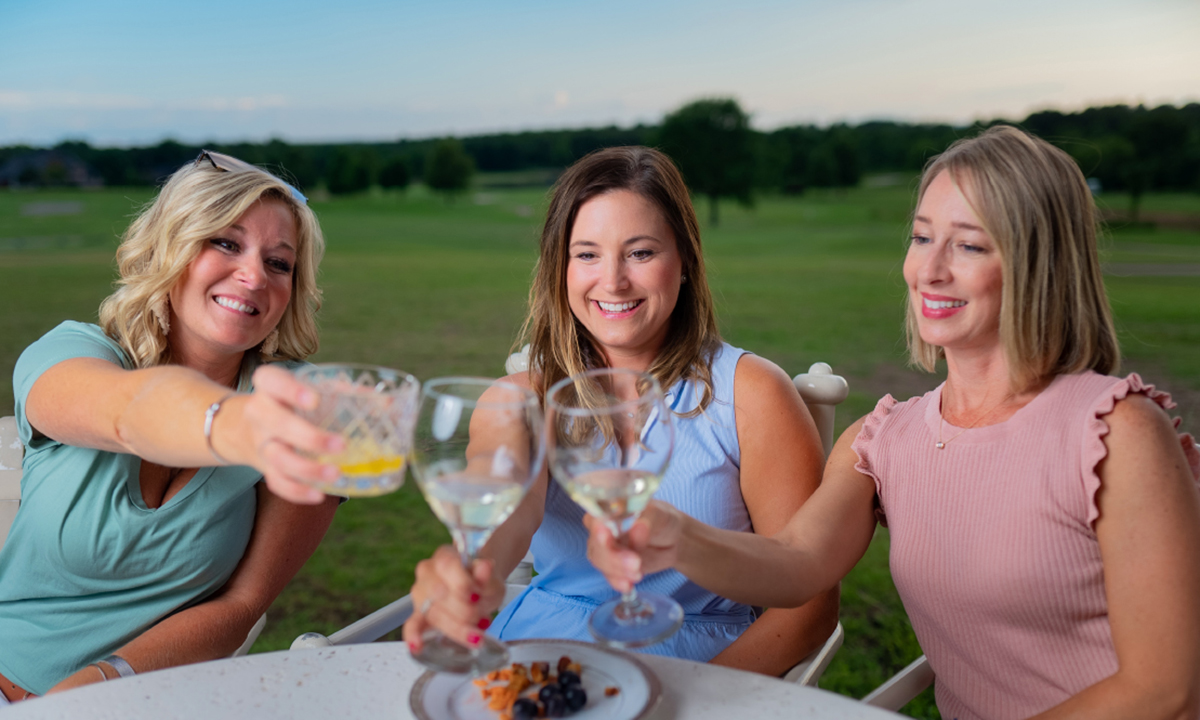 Three women toasting with wine glasses